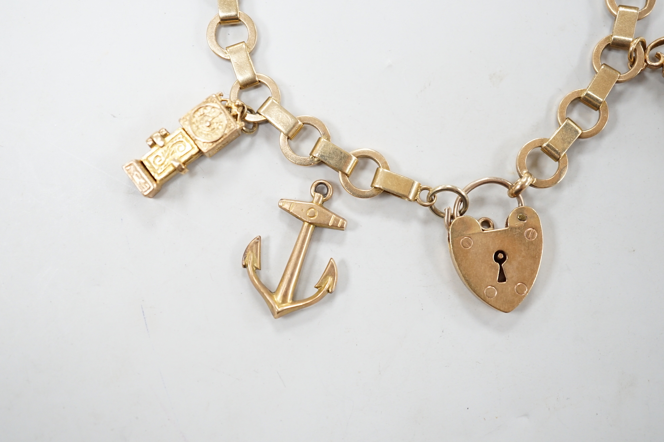A 1950's 9ct gold charm bracelet hung with six assorted charms, gross weight 25.5 grams.